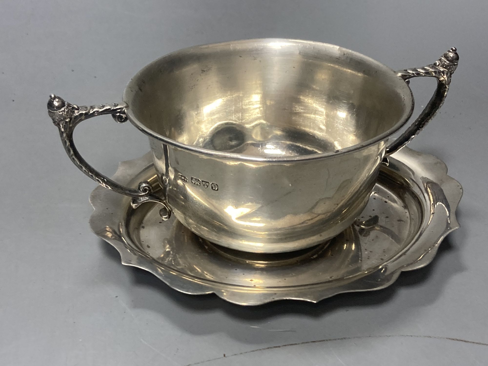 A late 19509s silver sauceboat on stand, Viners Ltd, Sheffield, 1958/9 and a George V silver porringer,